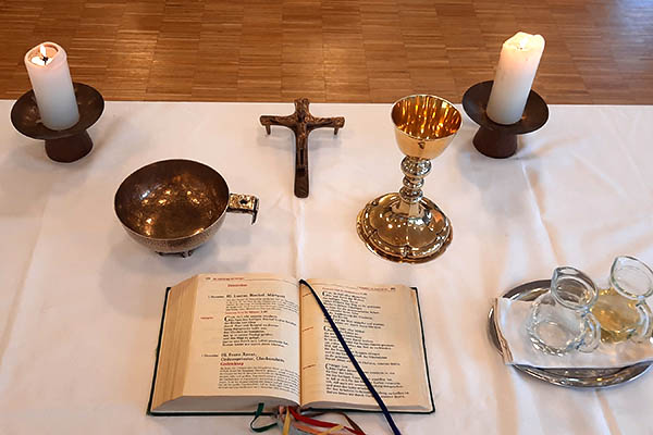 Altartisch mit 2 Kerzen, Messbuch, Kelch, Hostienschale, Wasser und Wein